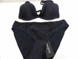 black bikini and panties on a white surface with a black tag