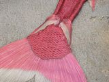a pink and white mermaid tail laying on the ground