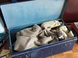 a blue suitcase with clothes inside of it on the floor