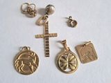 quatre breloques en or et une croix sur un fond blanc