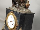 une statue de femme assise au sommet d'une horloge