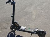 an electric scooter parked in a parking lot next to a building