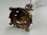 un objet en argent et en or surmonté d'un verre