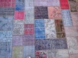 a person standing on a patchwork rug on the floor