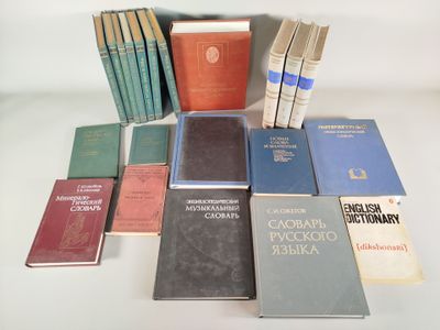 Plusieurs livres sont empilés sur une table devant un fond blanc.