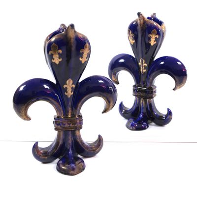 pair of blue and gold fleur de lis vases on a white surface
