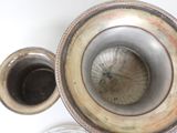 a silver vase that is sitting on a table