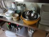 many bowls and pans sitting on a stainless steel shelf