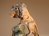 statue of a lion on a rock on a brown background