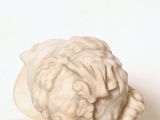 a white sculpture of a sheep on a white surface