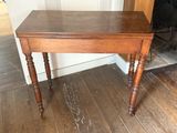 a small table with a wooden top on a hard wood floor