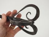 a hand holding a metal object that is shaped like a butterfly
