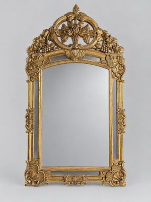 a large gold mirror with a floral design on the frame