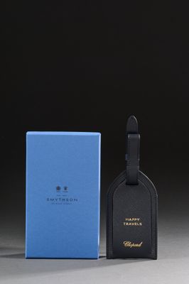 a blue and black luggage tag next to a blue box