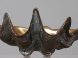 sculpture en bronze représentant une coquille de palourde posée sur un socle en acrylique transparent