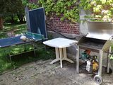 un barbecue avec une table et une table de ping-pong dans le jardin