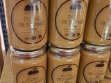 several jars of honey sit on a shelf in a store