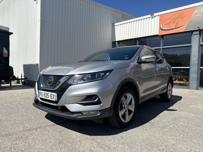 une Nissan QX argentée garée devant un immeuble