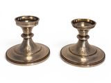 a pair of silver candlesticks on a white background