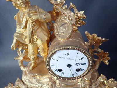 une horloge en or sur laquelle sont représentés un homme et une femme