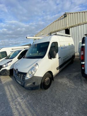 plusieurs fourgonnettes blanches garées sur un parking à côté d'un immeuble