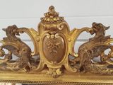 a gold frame with a clock on top of it