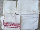 plusieurs serviettes blanches ornées de motifs rouges et blancs, posées sur une table