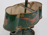 a green and gold lamp with a bird design on it