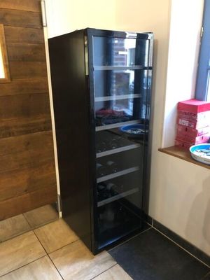 a black refrigerator in the corner of a room