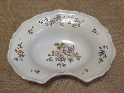 a white bowl with flowers on it on a table