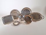 silver plated dishes and trays on a white surface