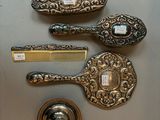 trois cuillères en argent, un peigne et un peigne posé sur une table