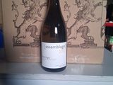 une bouteille de vin posée sur une étagère à côté d'une boîte de vin