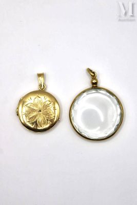 a close up of two gold pendants on a white surface