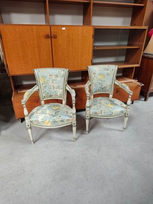 deux chaises et un meuble dans une pièce où se trouve une bibliothèque