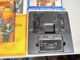 two cassettes and a cassette player sitting on a table
