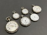 several different types of pocket watches sitting on top of a table