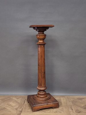 a wooden pedestal with a wooden top on a wooden floor