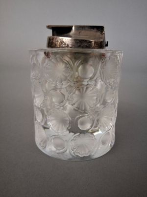 a clear glass jar with a silver lid on a table