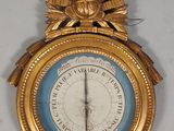 une horloge en or accrochée au mur, sur laquelle se trouve un cadran