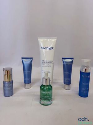 un ensemble de produits de soin de la peau posés sur une table blanche