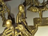 des figurines en laiton représentant un groupe de personnes assises sur une table