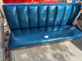 a blue bench that is sitting on the side of the road