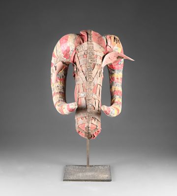 une photo d'une sculpture en bois représentant une tête de bélier posée sur un socle