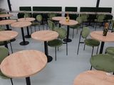 de nombreuses tables et chaises dans une pièce, avec une bouteille posée sur la table