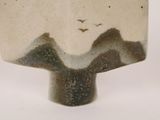 a close up of a vase with a bird flying in the sky