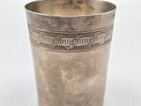 une vieille coupe en argent posée sur une table blanche