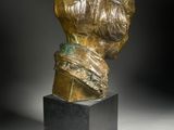 a bronze bust of a woman on a black pedestal