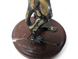 a statue of a man sitting on top of a wooden base