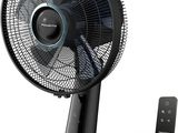 une photo d'un ventilateur noir posé sur une table, à côté d'une télécommande